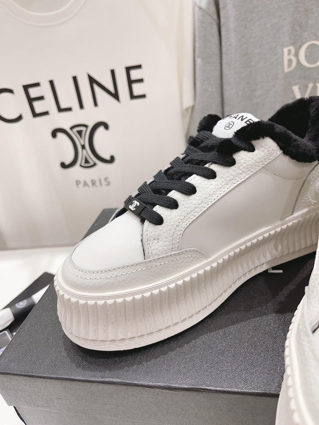 Women’s Chanel low-top sneakers, white with black laces, plush collar, ridged platform