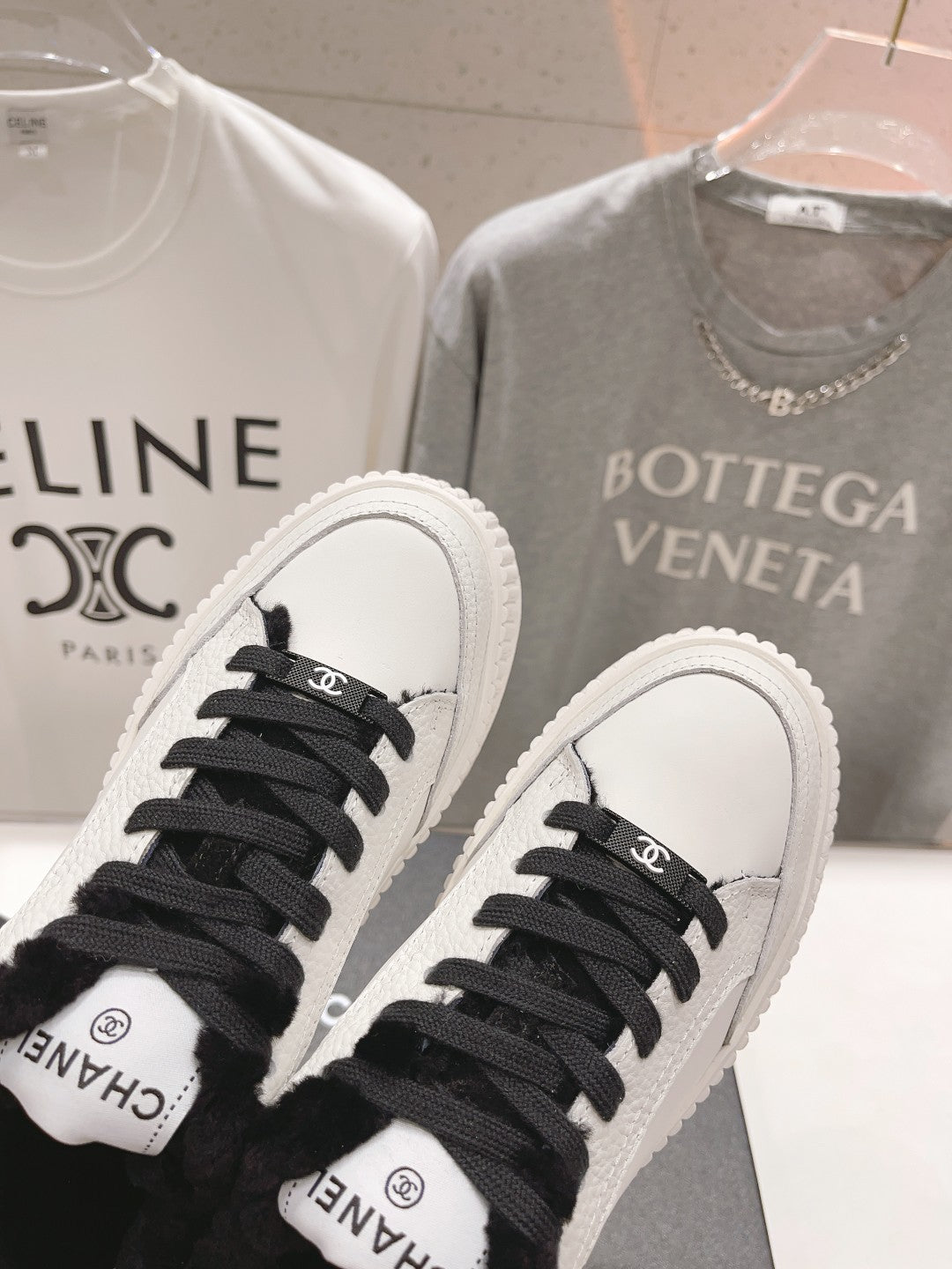 Women’s Chanel sneakers close-up: white toe caps, black laces, plush collar details