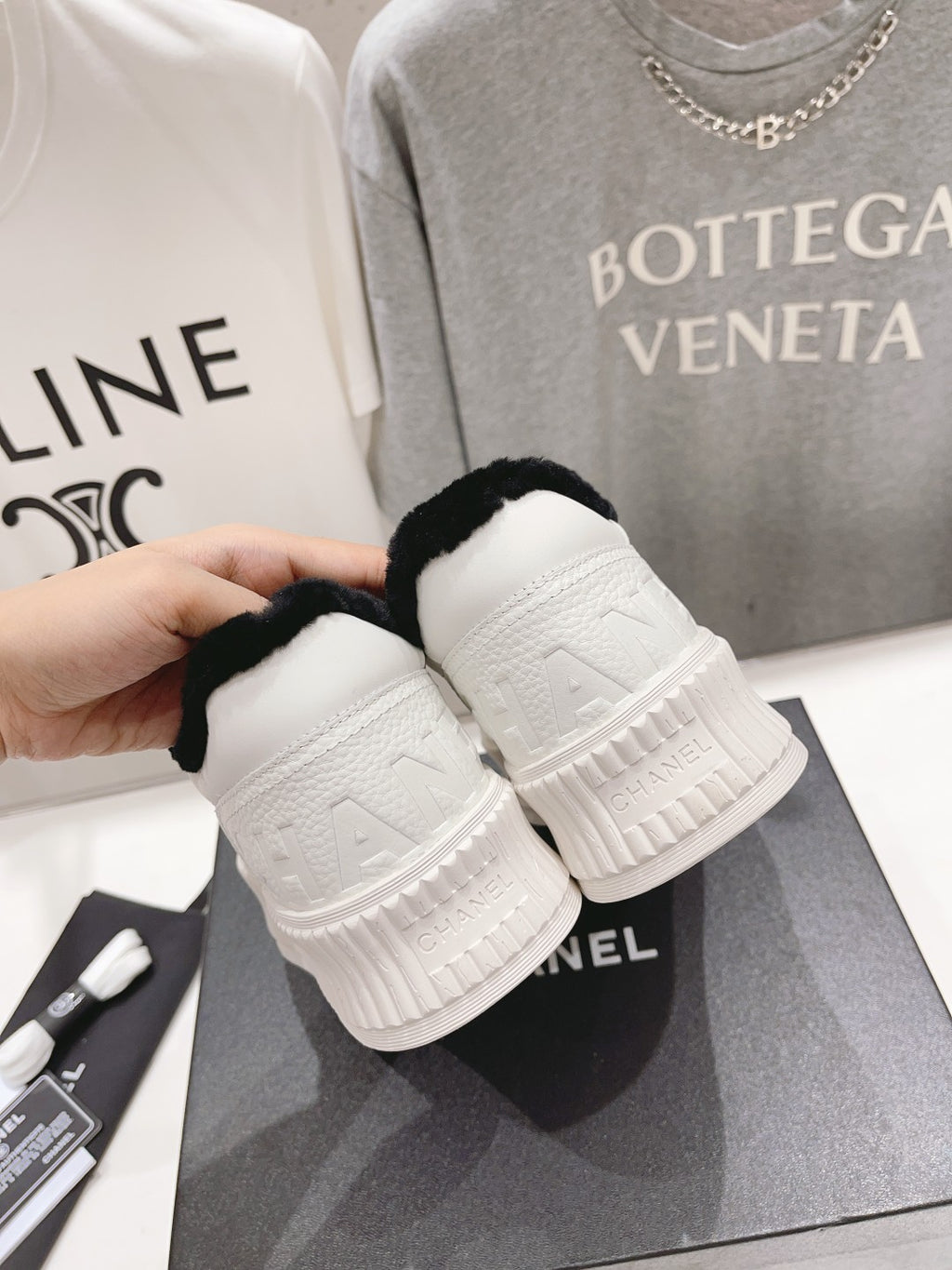 Women’s Chanel sneakers heel close-up, white platform sole with embossed logo panels