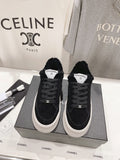 Ladies black lace-up sneakers with white ridged sole and Chanel logo label on tongue