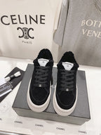 Ladies black lace-up sneakers with white ridged sole and Chanel logo label on tongue
