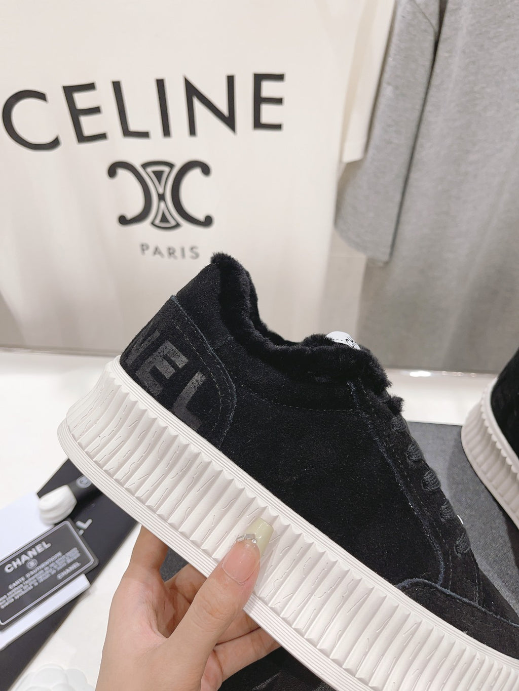 Close-up of black fuzzy upper and white ridged sole on a lace-up sneaker with Chanel