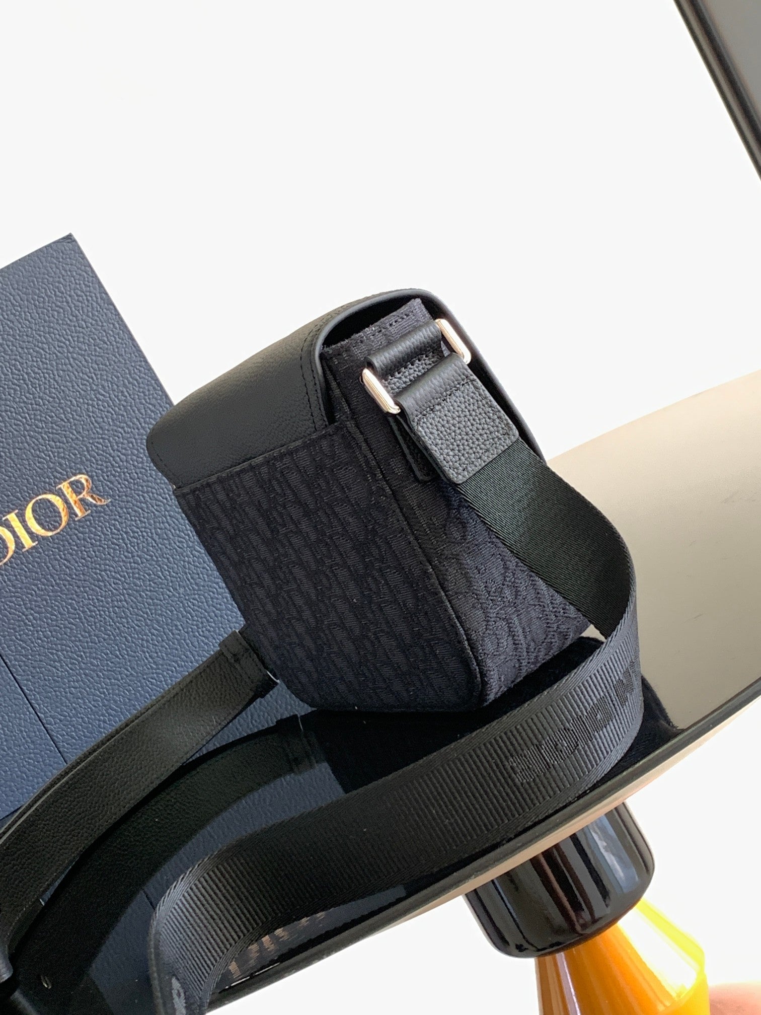 Dior crossbody bag with flap buckle and adjustable strap, dark side view