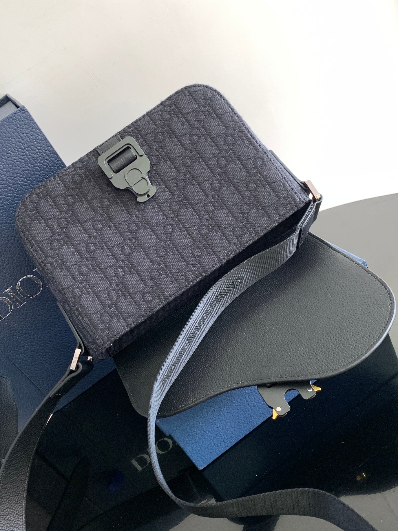 Dior crossbody bag front view with top buckle and adjustable strap, dark pattern