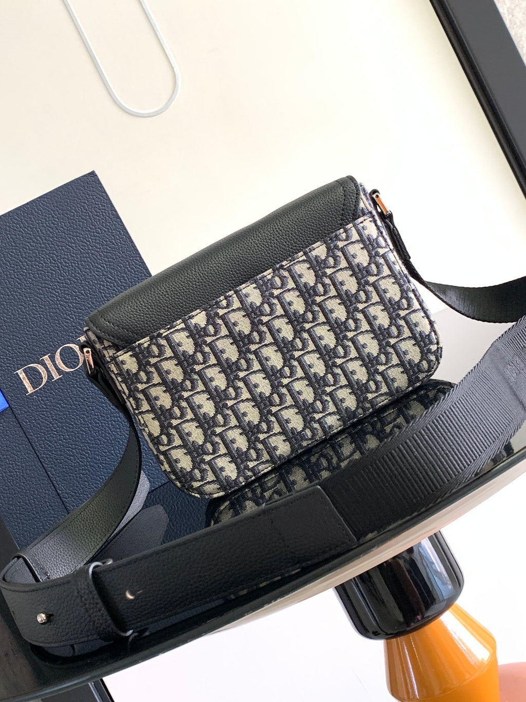 Dior bag with gray shoulder strap and Dior monogram canvas front, side view