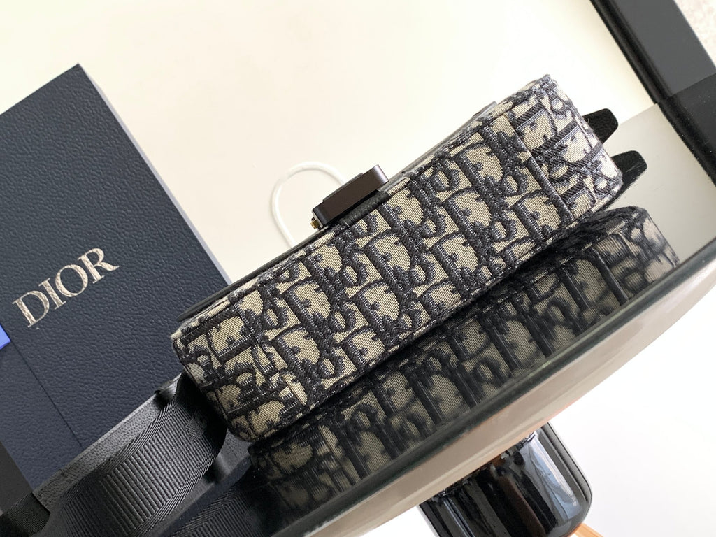 Dior bag showing Dior monogram canvas strap attachment and black leather handles