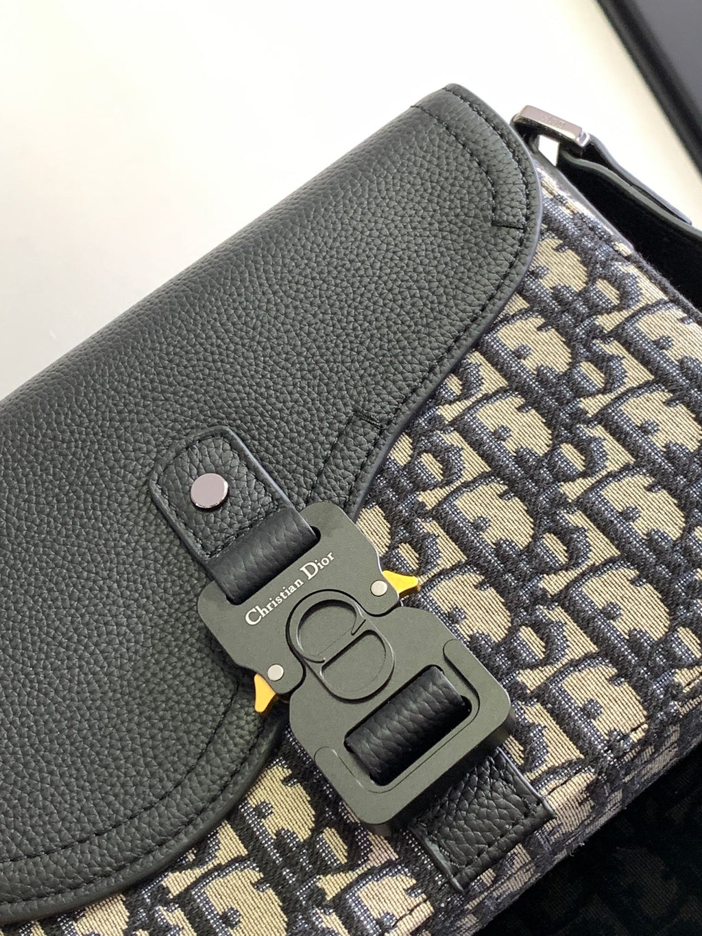 Dior bag close-up: black leather flap with Dior engraved hardware and logo tag
