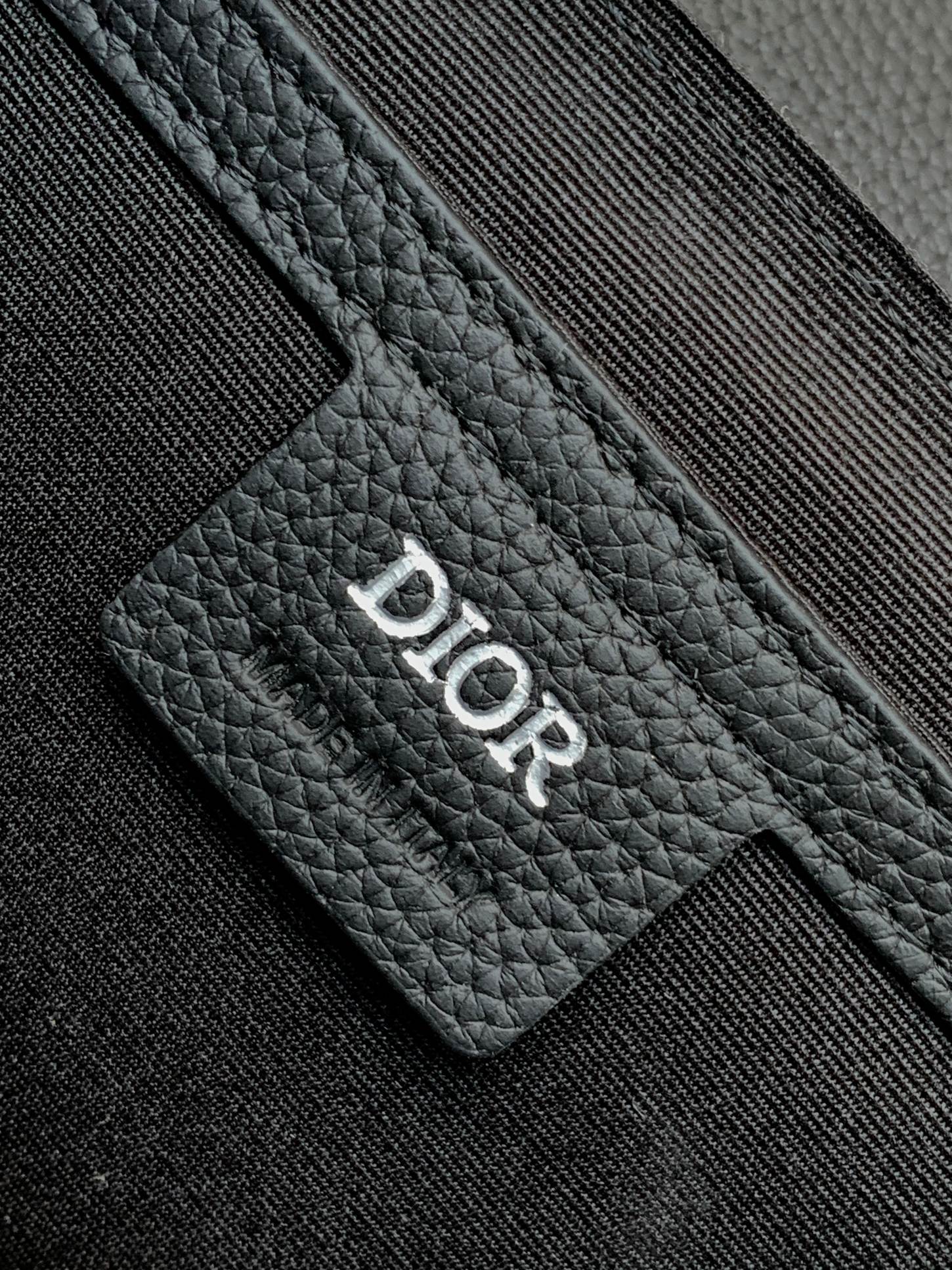 Dior bag detail: Dior logo stamped on black textured leather card holder