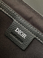 Dark leather bag interior label with Dior logo patch and stitched pocket