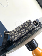 Crossbody bag with navy and beige Dior pattern and black adjustable shoulder strap