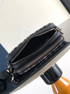 Crossbody bag open view with black interior, zip pockets, and navy/beige patterned exterior