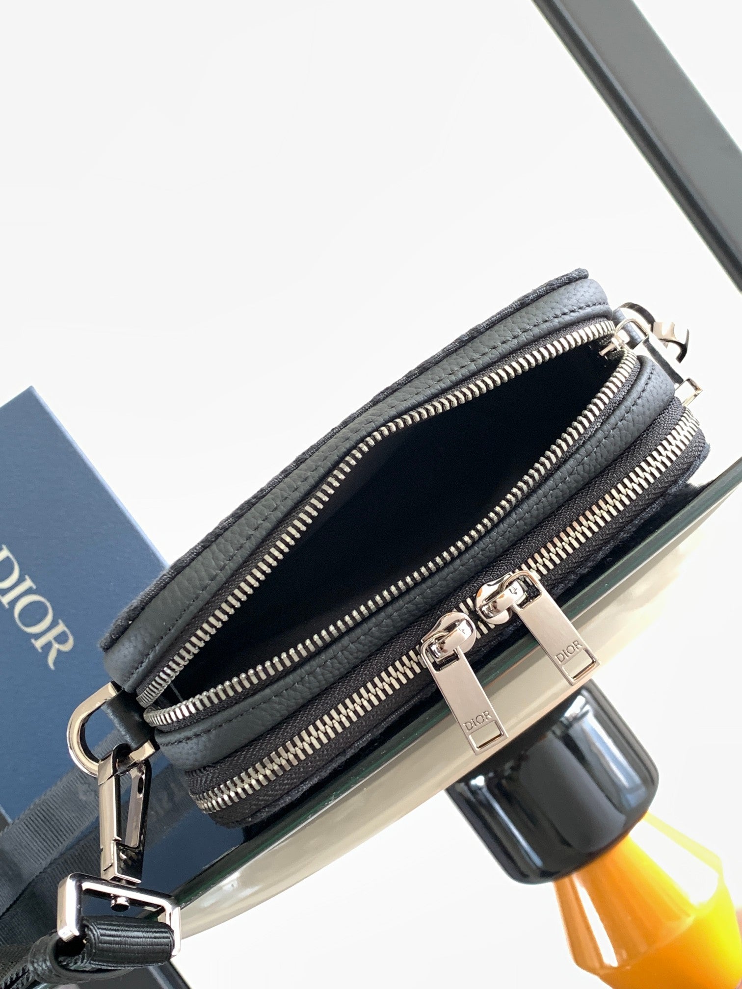 Dior bag dark navy with two zipper compartments and slim strap across body
