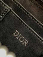 Dior bag dark navy textured surface with engraved DIOR logo lettering