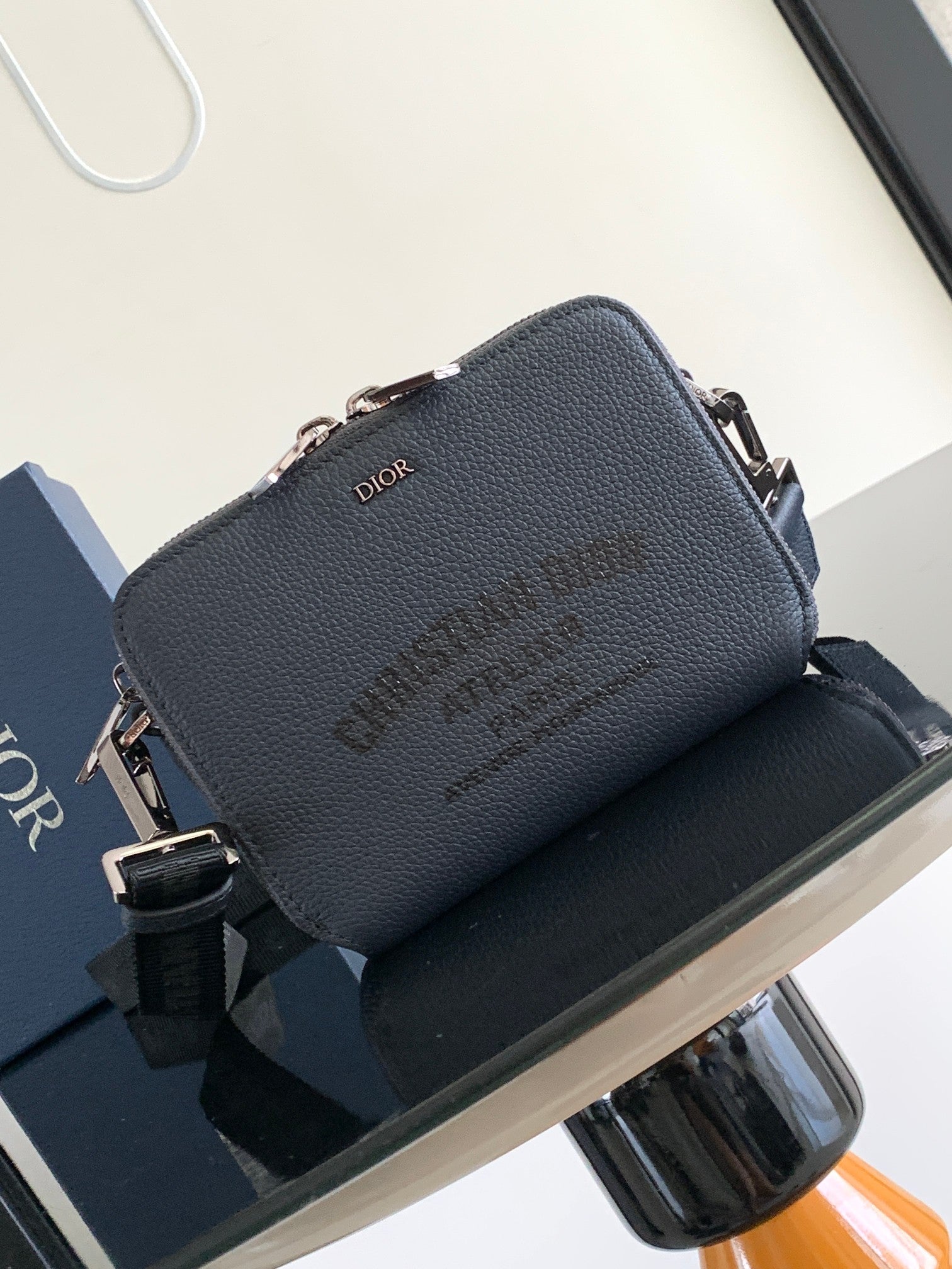 Navy leather Dior crossbody bag with top zipper and front Dior logo, adjustable strap
