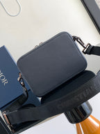 Navy leather crossbody bag with top flap and silver hardware, wide shoulder strap