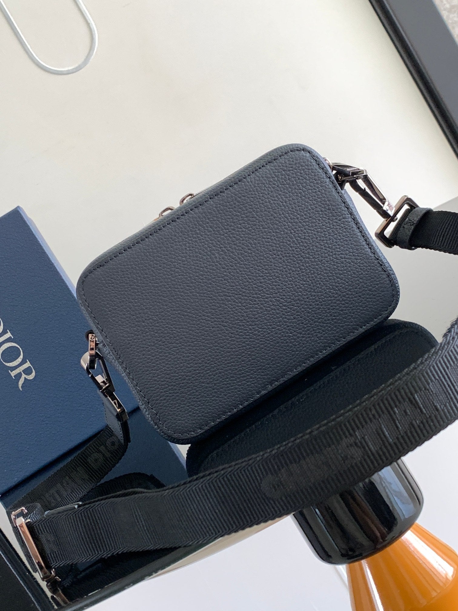 Navy leather crossbody bag with top flap and silver hardware, wide shoulder strap