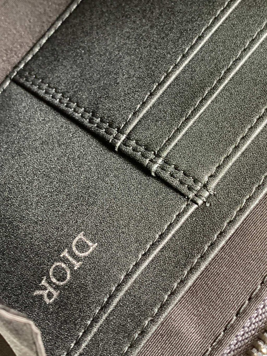 Dark fabric strap with stitched edge and Dior lettering