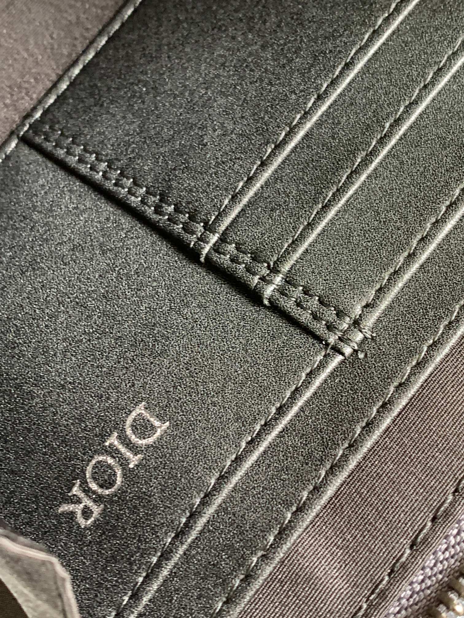 Dark fabric strap with stitched edge and Dior lettering