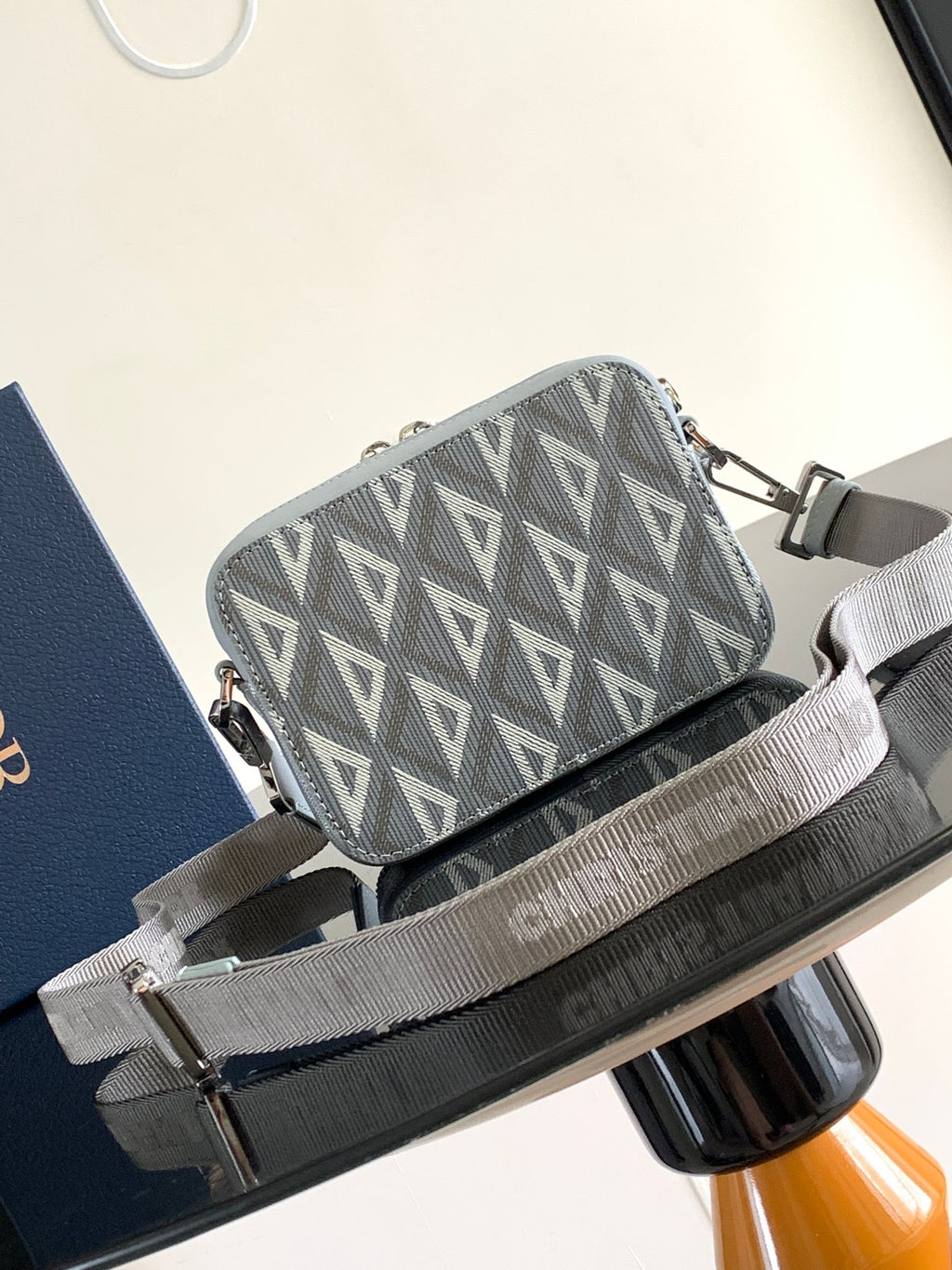 Dior mini crossbody bag with gray Dior Oblique pattern, light blue leather trim, and zip top