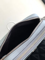 Dior mini bag interior view with zip opening and black lining, light blue leather edges