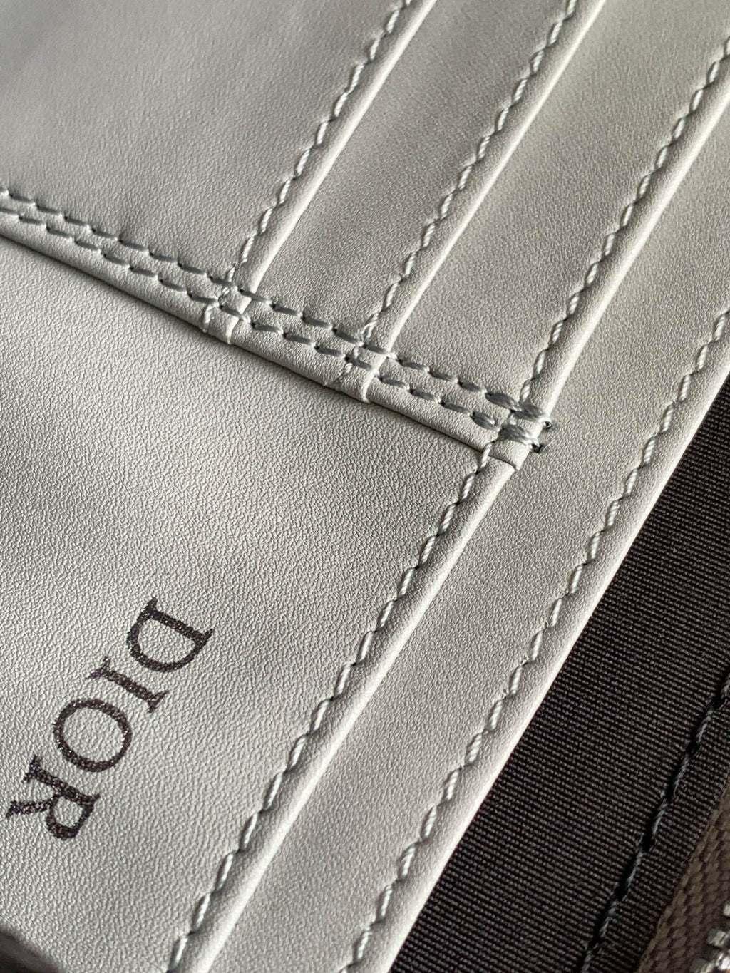 Dior mini bag leather close-up with stitched seams and embossed Dior logo