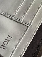 Dior mini bag leather close-up with stitched seams and embossed Dior logo