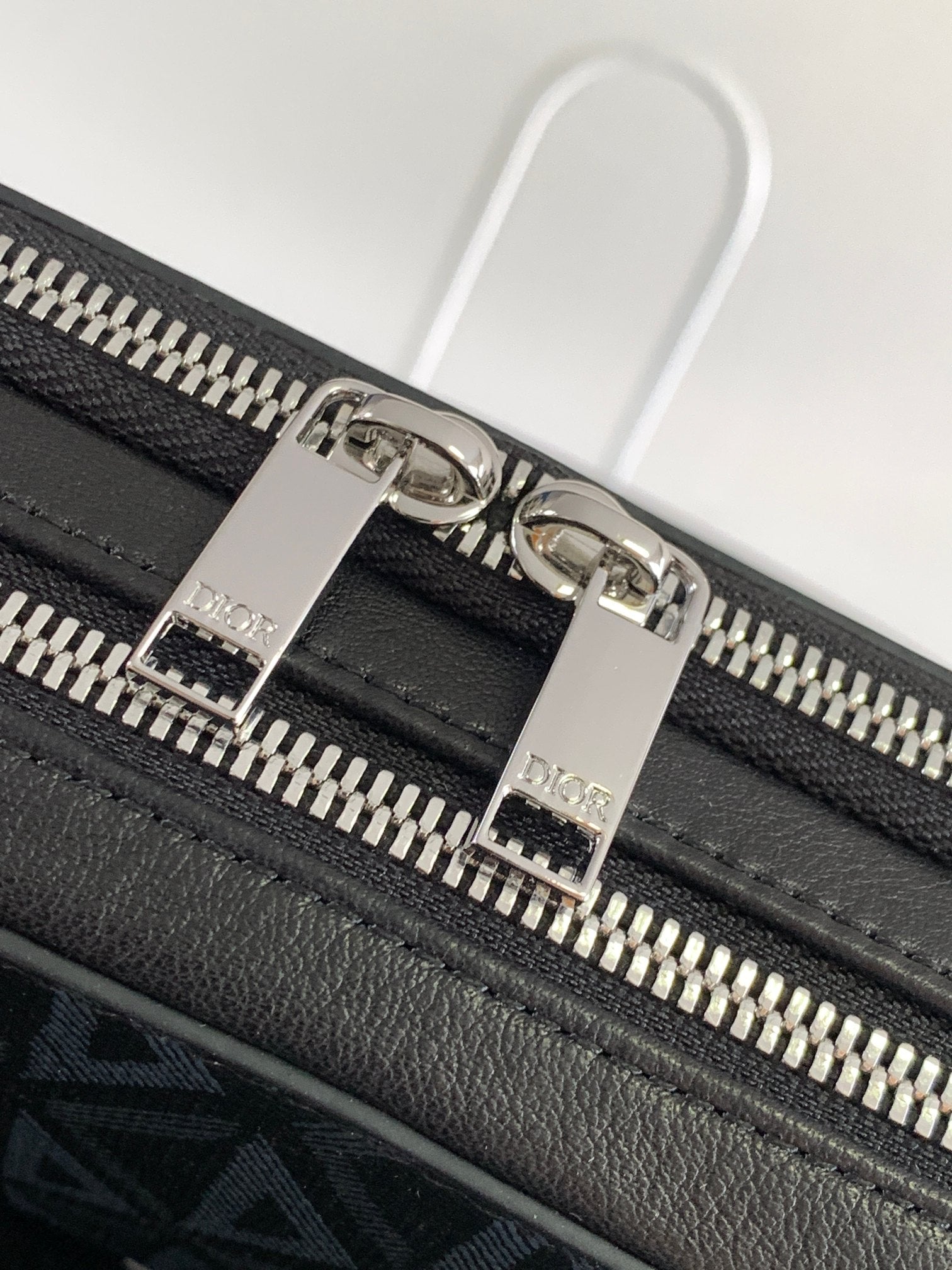Black leather bag with silver-tone zipper pulls and Dior-engraved hardware