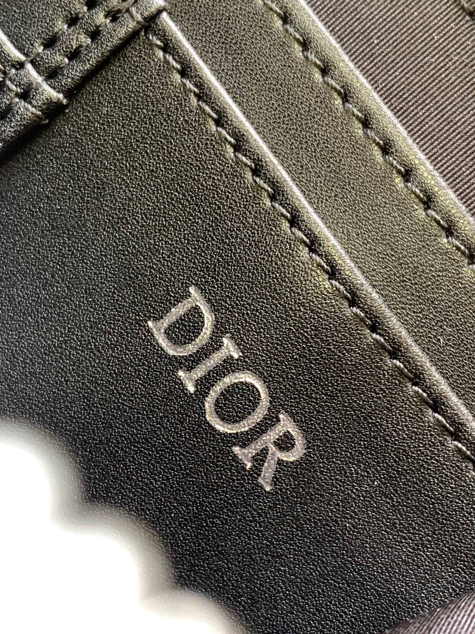 Black leather Dior logo tab with edge stitching