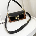 Coah Bags handbag, black with brown front panel, gold studs and hardware, single strap.