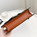 Coah Bags handbag underside, brown leather base with gold studs and corner feet.