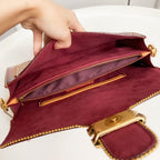 Coah bag open view showing burgundy suede interior and gold-tone zipper