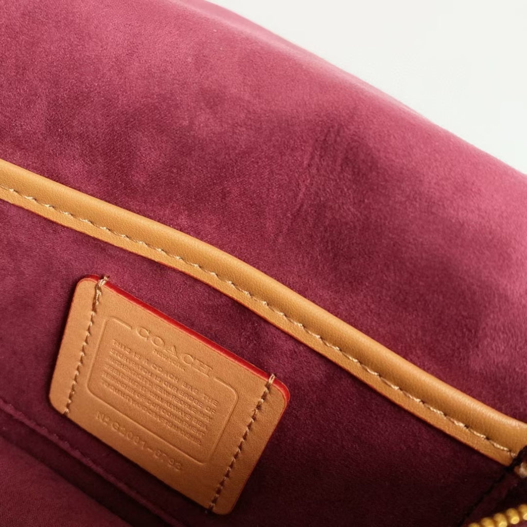 Coah bag label patch on burgundy suede interior with gold trim