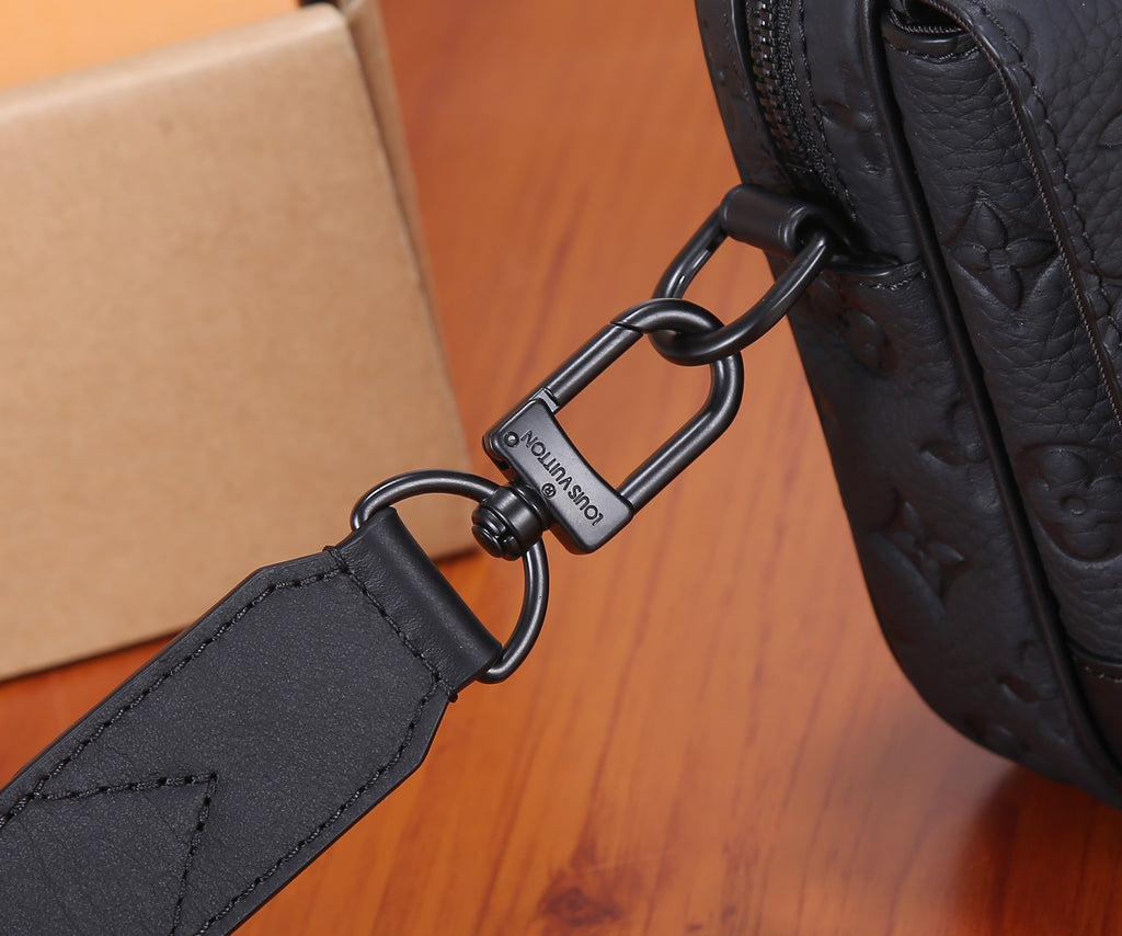 Louis Vuitton strap end with metal buckle and ring on dark leather bag