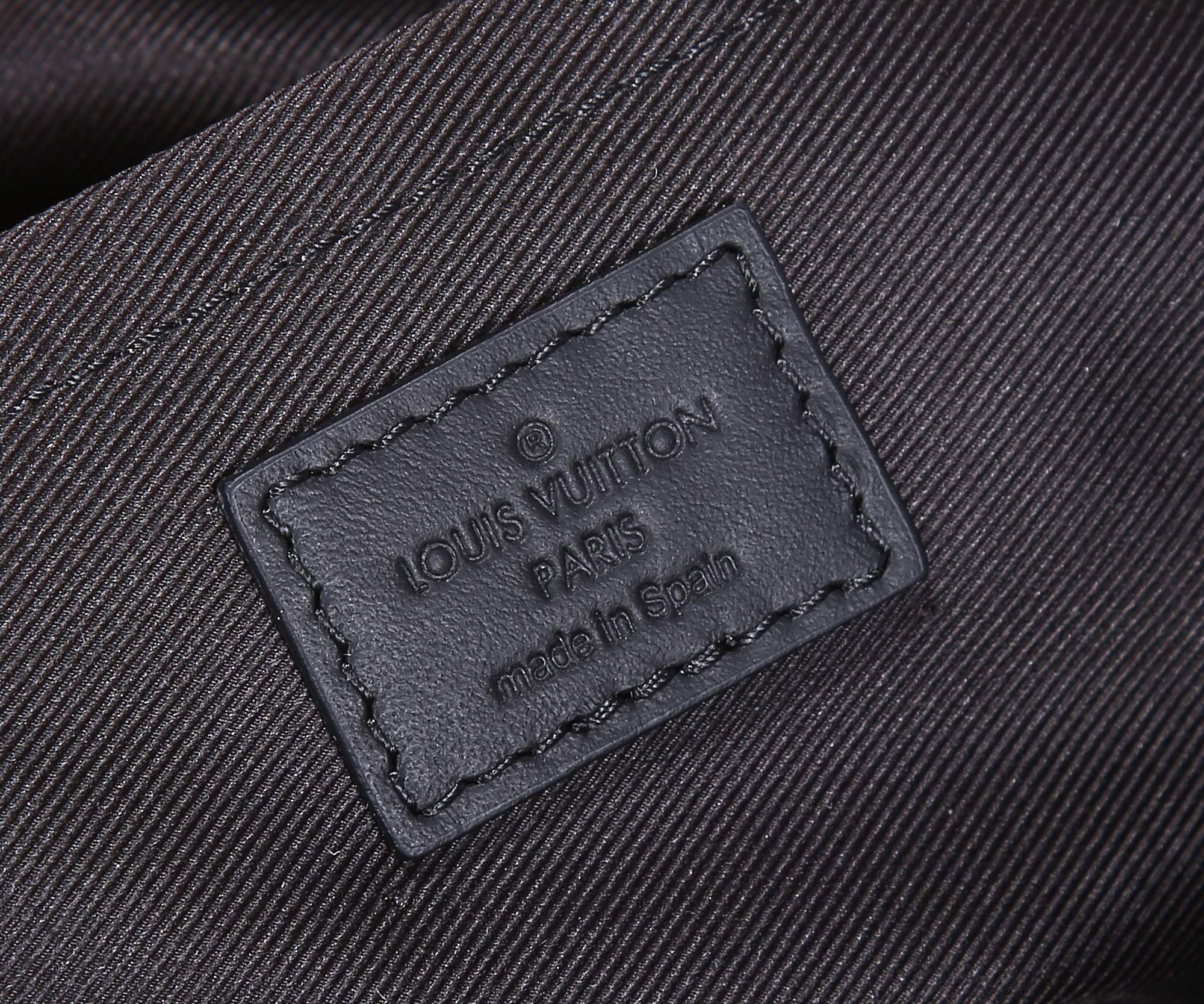 Dark fabric label on bag lining reading Louis Vuitton Paris and made in Spain