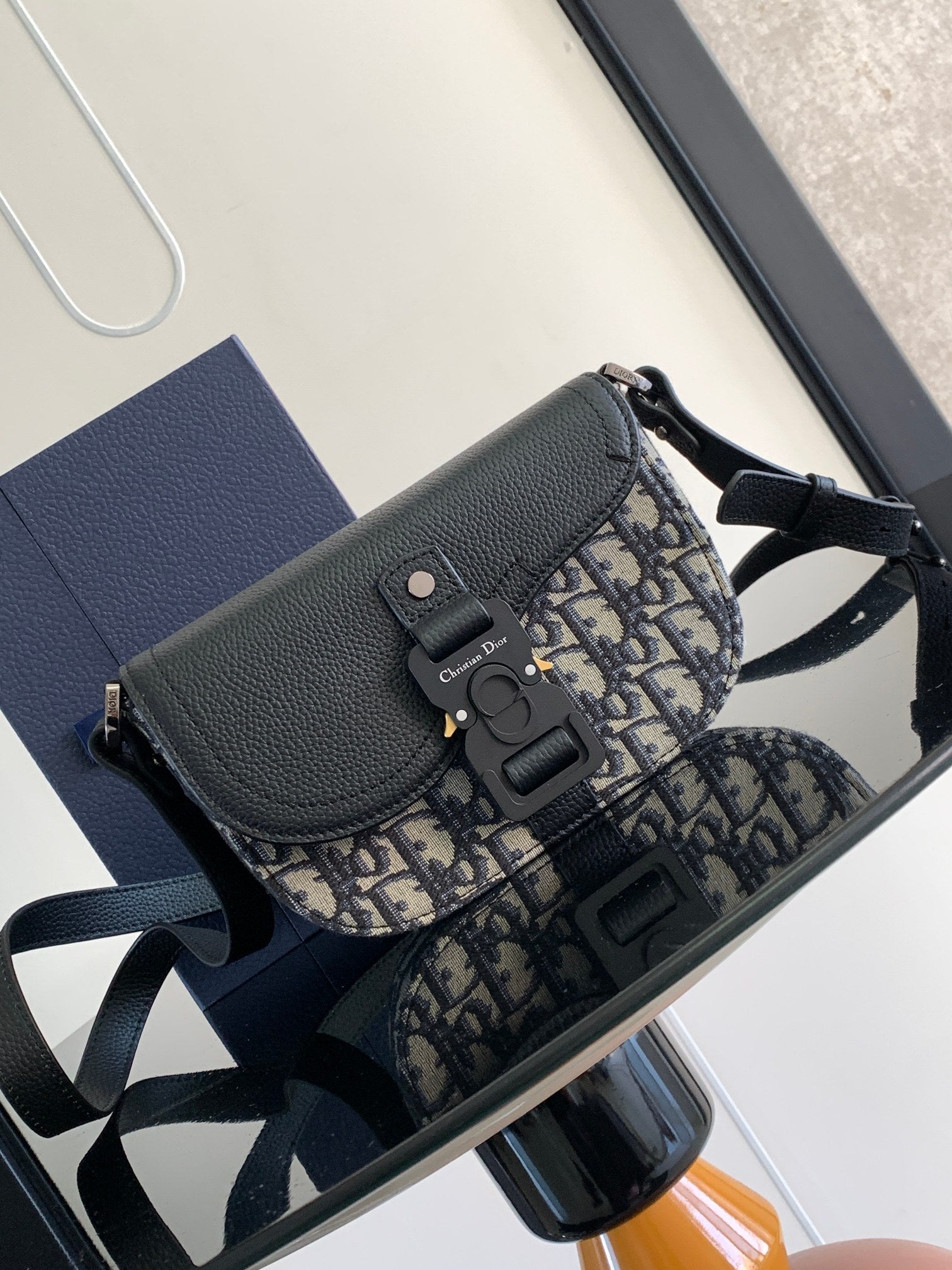Dior mini bag with navy pebbled leather flap and blue-and-beige patterned canvas strap