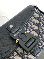 Dior mini bag front with textured dark leather, Dior hardware charm, and monogram panel