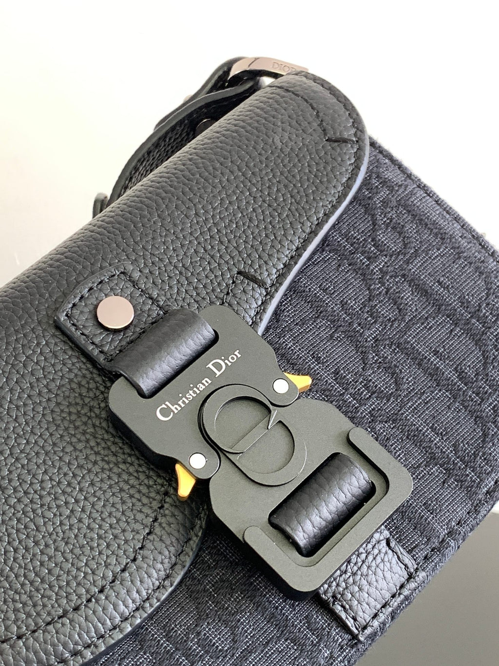 Dior small crossbody bag, dark pebbled leather with metal hardware and Dior charm