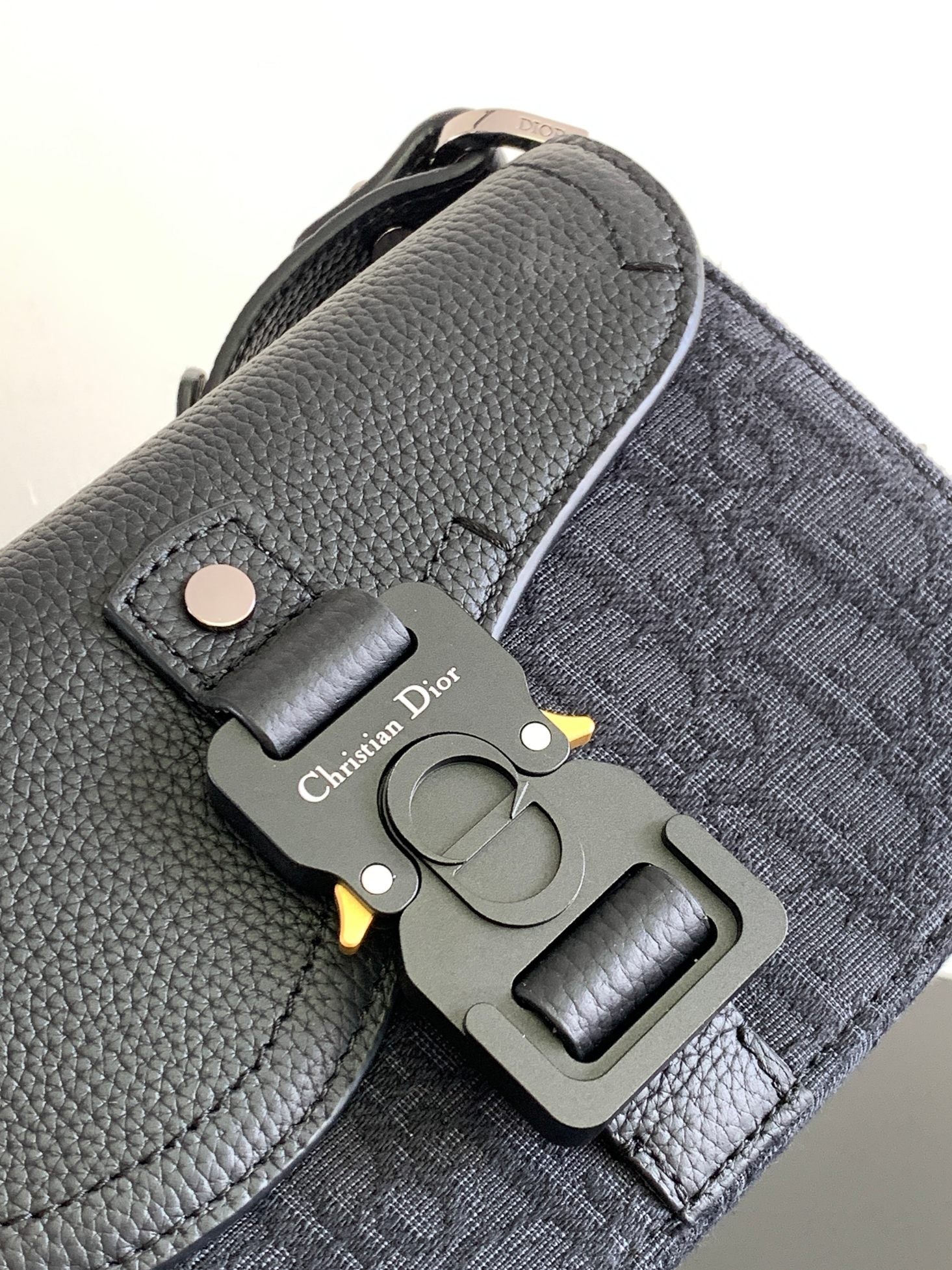 Dior small crossbody bag, dark pebbled leather with metal hardware and Dior charm