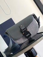 Dior bag in gray textured leather with flap, black buckle and strap hardware.