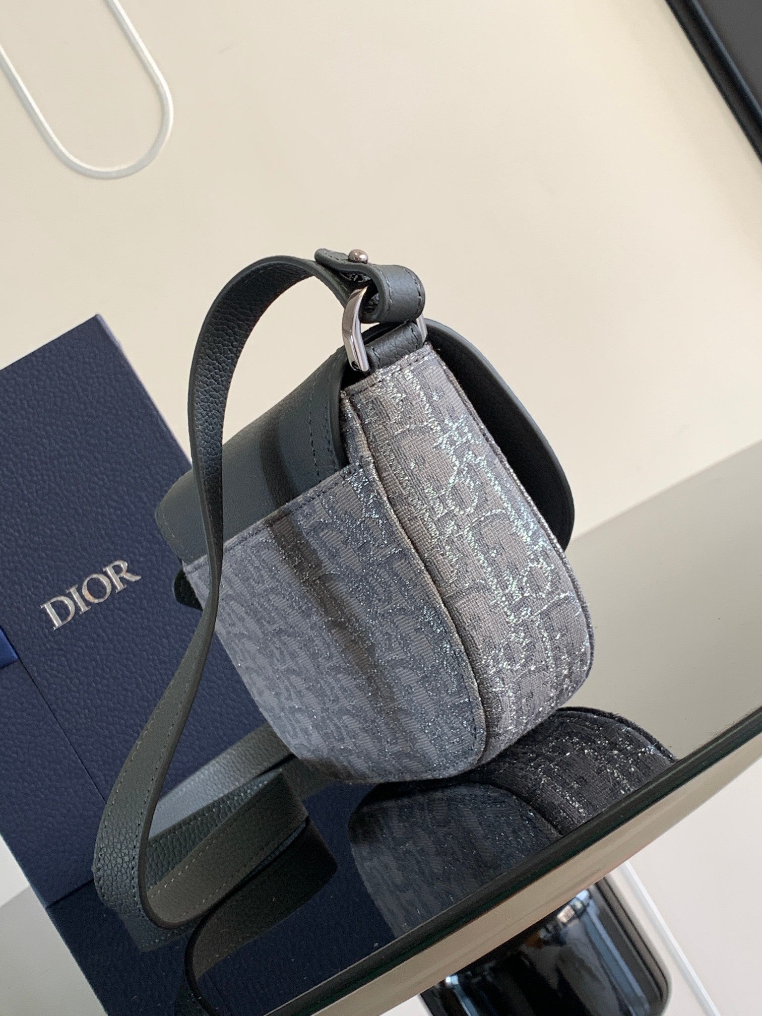 Dior gray patterned mini bag with top handle and adjustable crossbody strap.