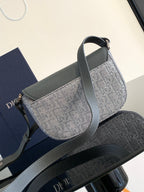 Dior gray small bag with curved flap, patterned body, and side strap detail.