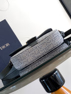 Dior gray patterned baguette-style bag with top handle and front buckle hardware.