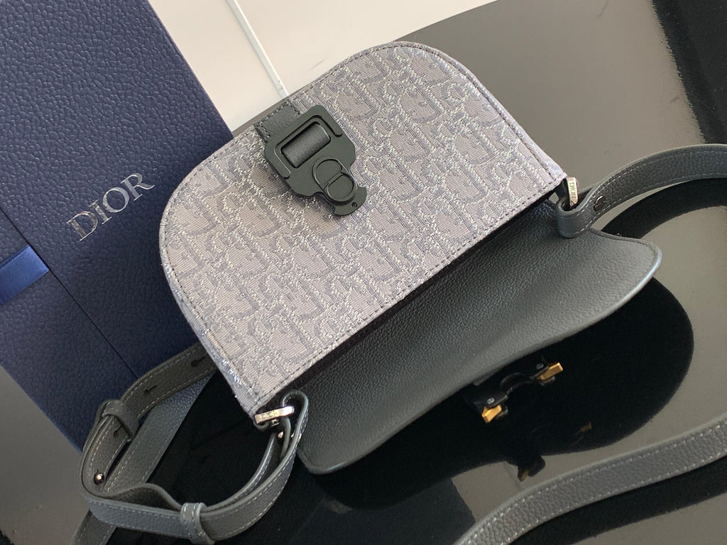 Dior gray and dark gray mini bag with front emblem detail and crossbody strap.