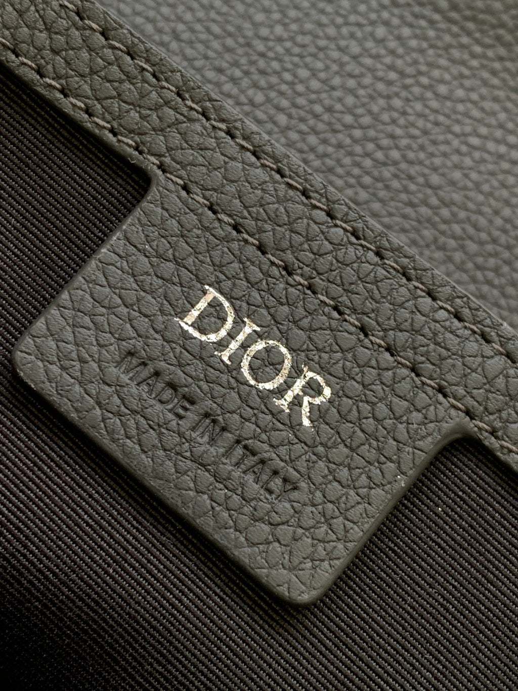 Dior gray leather card slot with Dior logo embossed on the panel.