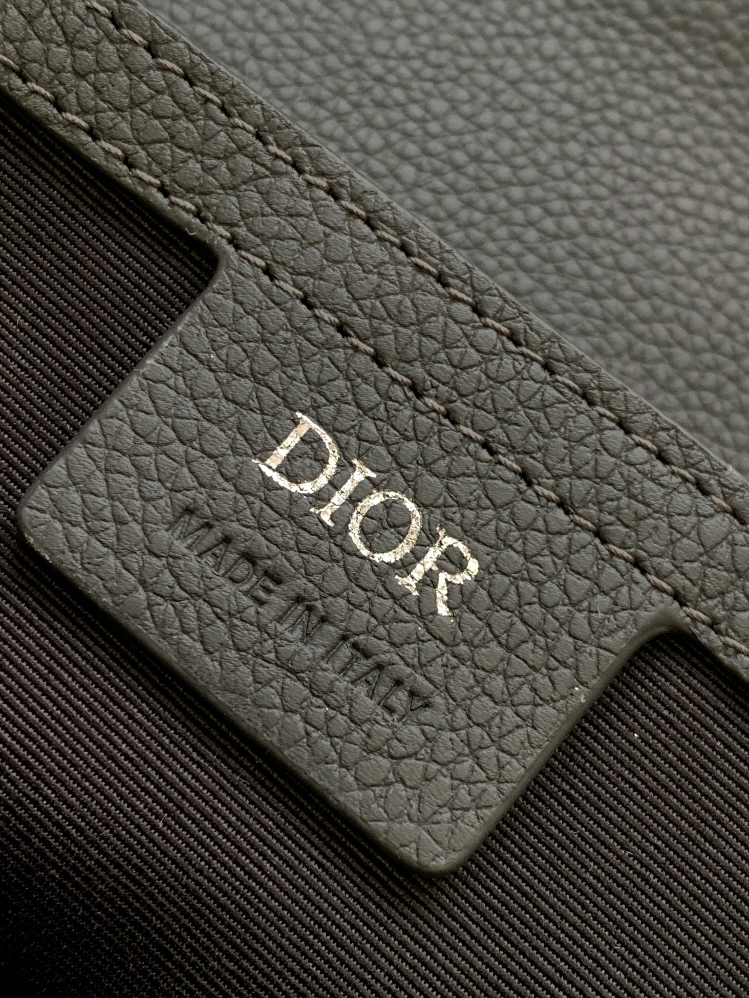 Dior gray leather card slot with Dior logo embossed on the panel.