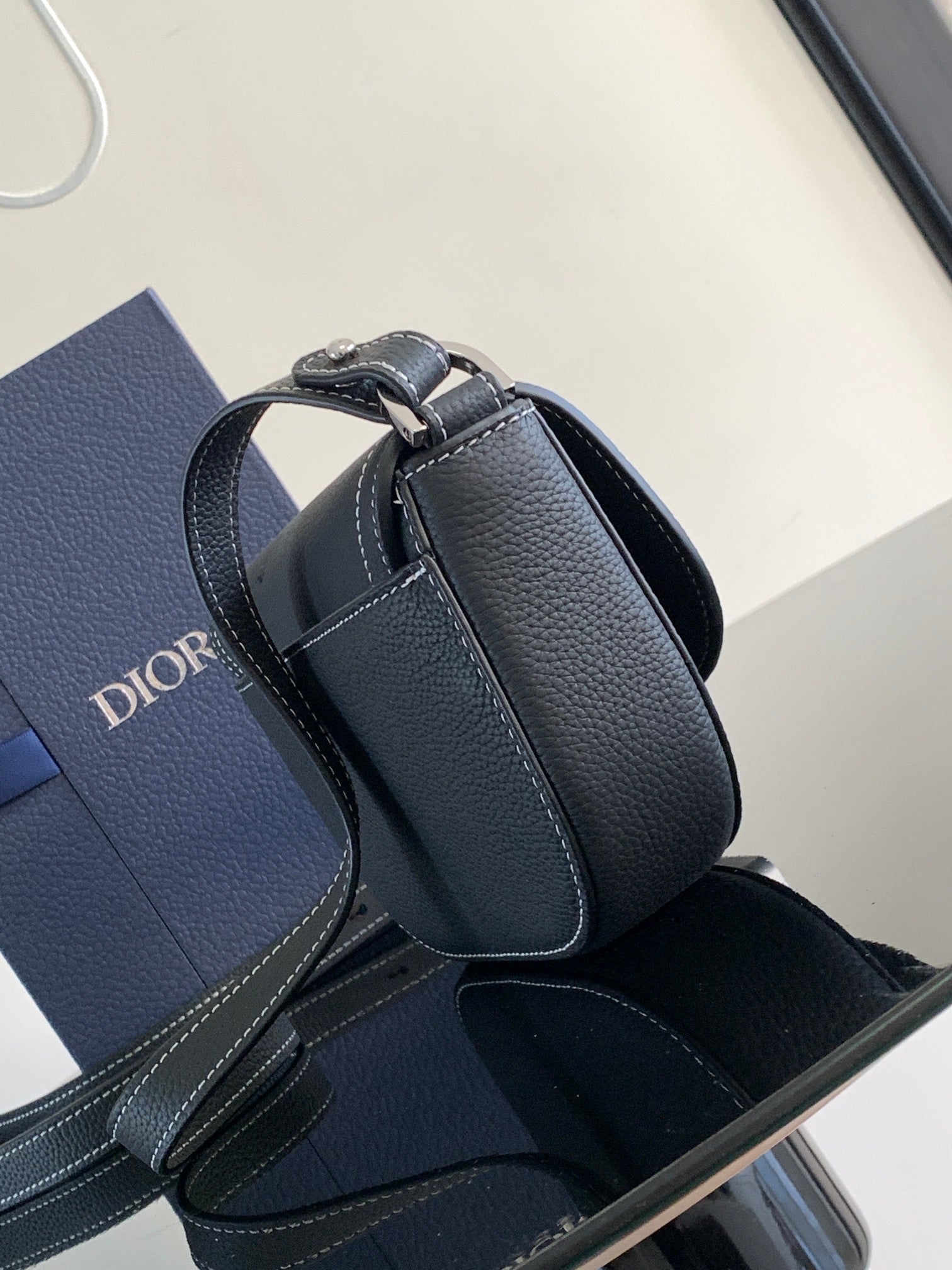 Dark leather Dior mini bag with curved flap top handle and front tab detail