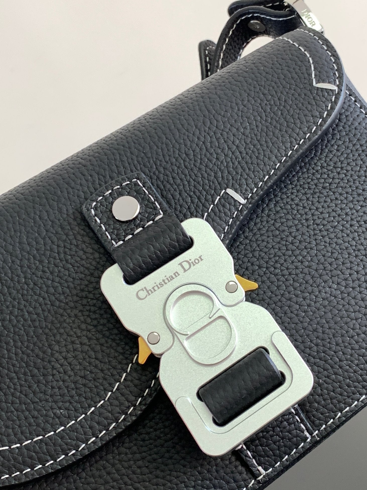 Dark leather Dior bag with silver logo plate charm and snap button closure