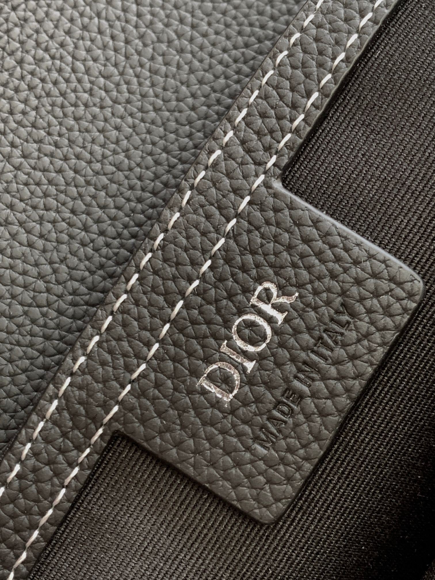 Dior logo leather patch on a dark textured bag, with white contrast stitching
