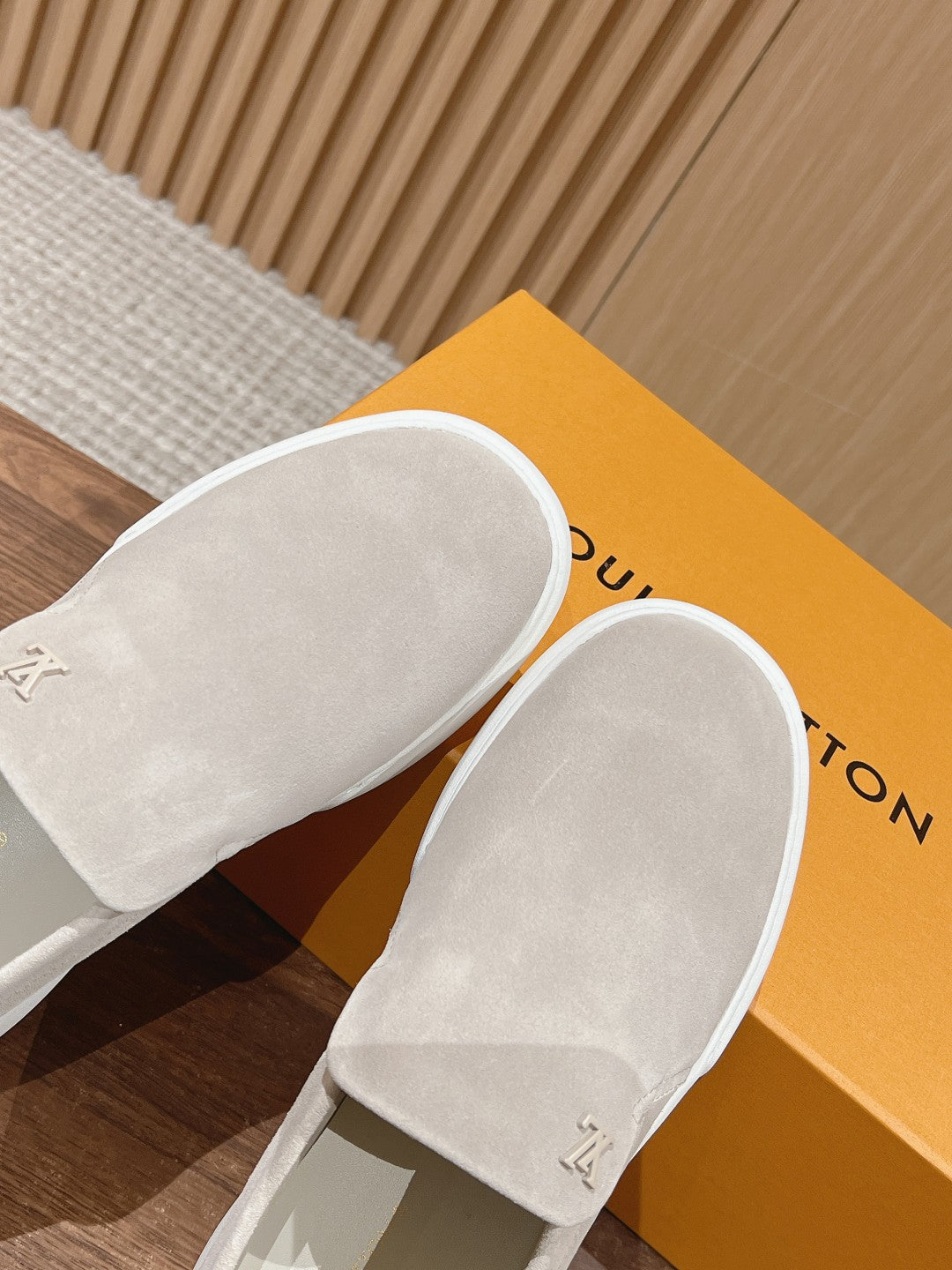 Louis Vuitton suede slip-on shoes, light beige, angled view on box