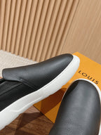 Black leather slip-on sneaker close-up with white rubber sole edge
